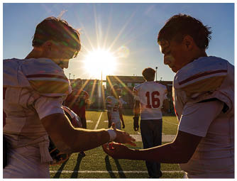 Two football players shaking hands. Description generated by AI