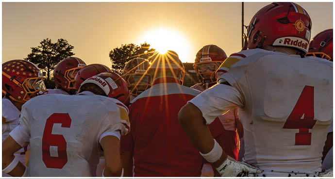 A group of football players wearing red and white uniforms. Description generated by AI