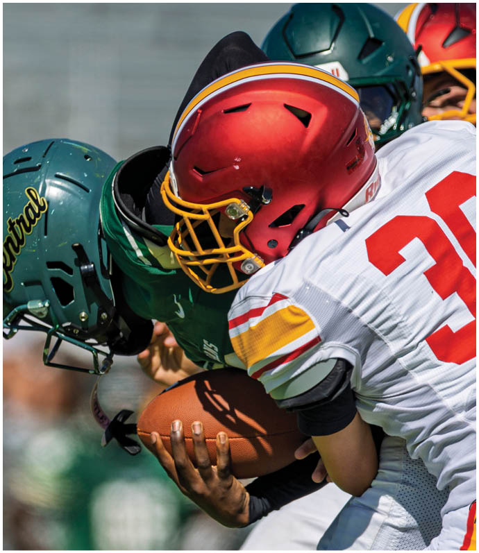 Two football players wearing red and white uniforms. Description generated by AI