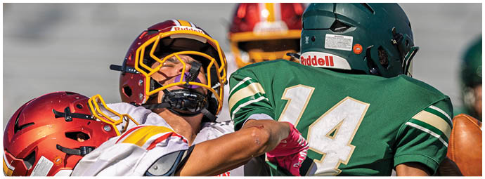 A football player wearing a red and yellow jersey. Description generated by AI