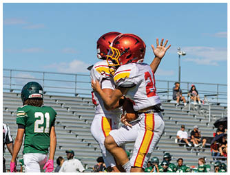 A young boy wearing a red and yellow Northglenn jersey. Description generated by AI