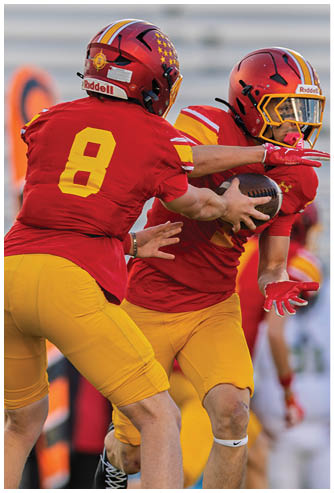A football player wearing a red and white jersey with the number 9 on it. Description generated by AI