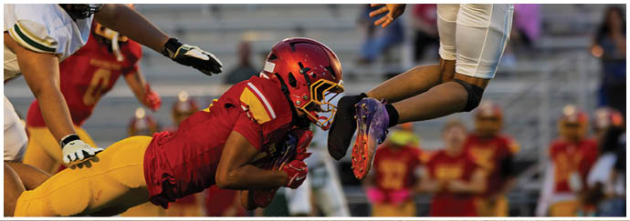 A football player in a black jersey is tackling another player. Description generated by AI