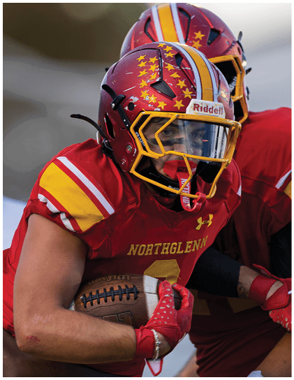A football player wearing a red and white jersey. Description generated by AI