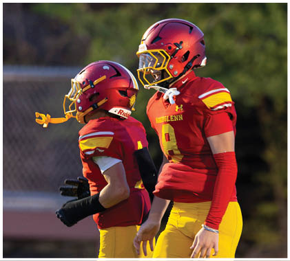 A group of football players running on a field. Description generated by AI