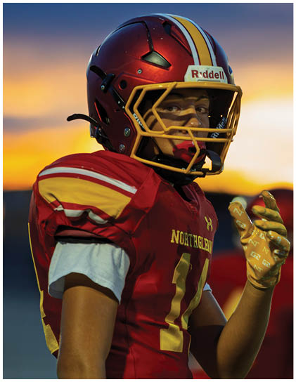 A football player wearing a red and white jersey. Description generated by AI