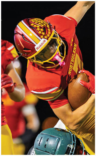 Two football players wearing white uniforms with red and yellow stripes. Description generated by AI