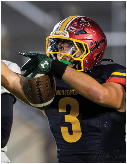A football player wearing a red and white jersey. Description generated by AI