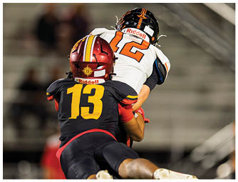 A football player wearing a red helmet and white jersey with the number 7. Description generated by AI