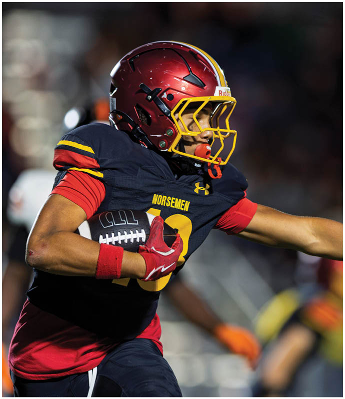 A football player in a white jersey with the number 2 on it is running with the ball. Description generated by AI