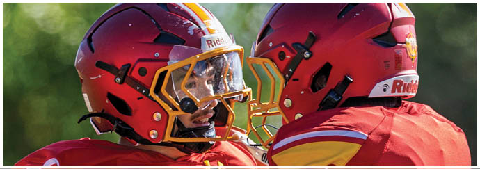 A football player in a white jersey with a red stripe is running with a football. Description generated by AI