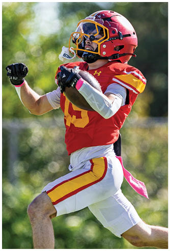 A football player wearing a red and white jersey with the number 9 on it. Description generated by AI