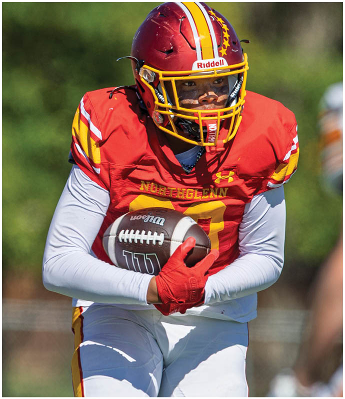 A football player in a white jersey with the number 2 on it is running with the ball. Description generated by AI