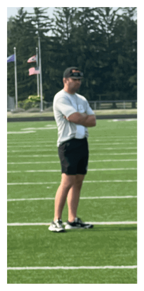 A football player is kneeling on the field, wearing a green jersey and a helmet. AI generated content
