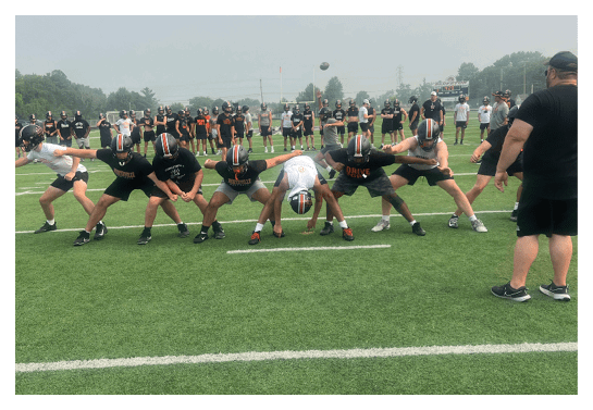 A group of football players wearing headphones and smiling. AI generated content