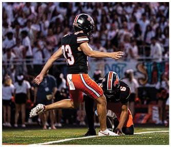 A group of football players wearing black and white uniforms. Description generated by AI