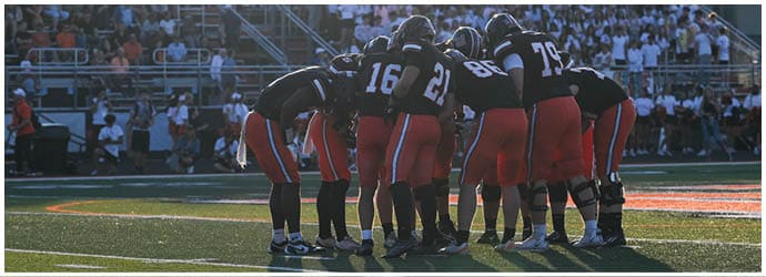 A group of football players on a field. Description generated by AI
