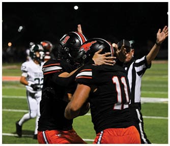 A group of football players wearing black and white uniforms. Description generated by AI