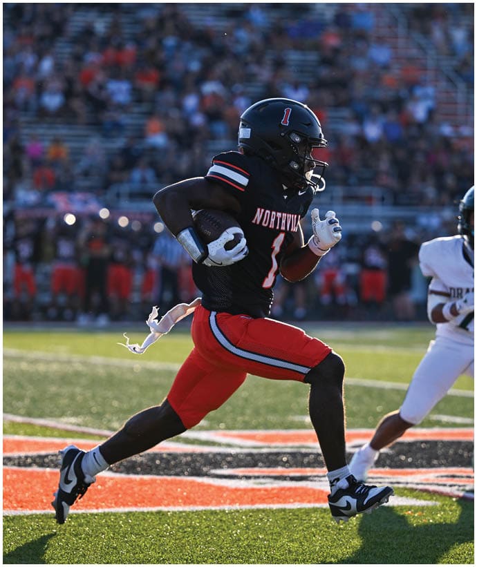 A group of football players wearing black and white uniforms. Description generated by AI