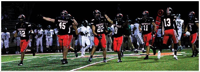 A group of football players on a field. Description generated by AI