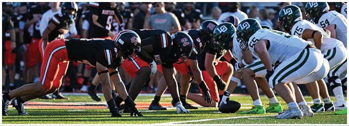 A group of football players on a field. Description generated by AI