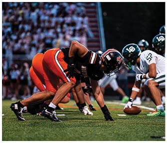 A group of football players wearing black and white uniforms. Description generated by AI