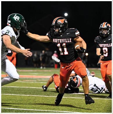A football player running on the field. Description generated by AI