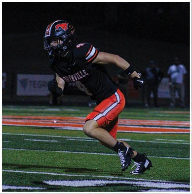 A football player running on the field. Description generated by AI