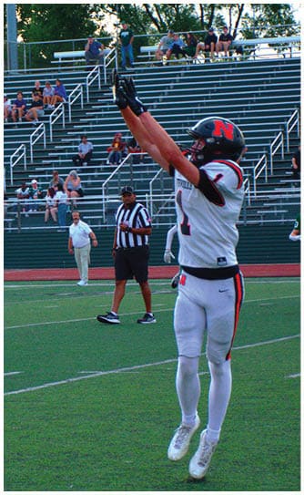 A football player catching a ball. Description generated by AI