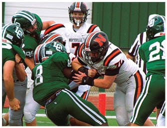 A group of football players on a field. Description generated by AI