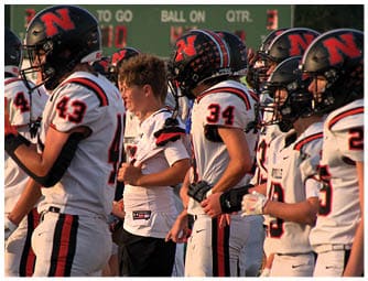 A group of football players on a field. Description generated by AI