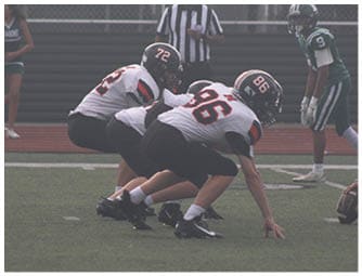 A group of football players on a field. Description generated by AI