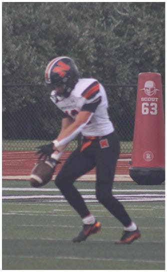 A football player catching a ball. Description generated by AI