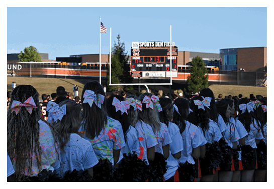 A group of people are kneeling on a field, possibly in a football game. AI generated content
