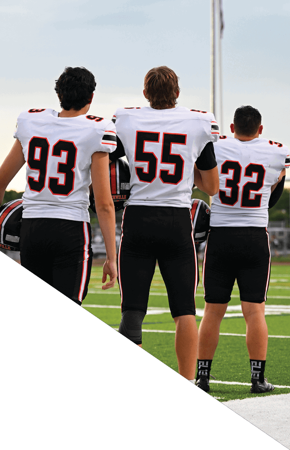 A football player is kneeling on the field, holding his helmet in his hands. AI generated content
