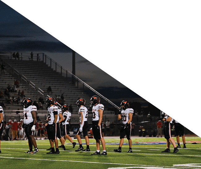 A group of football players kneeling on the field, some with their hands on their heads. AI generated content