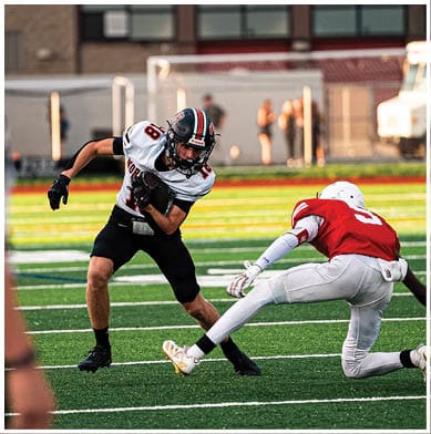 A football player running on the field. Description generated by AI
