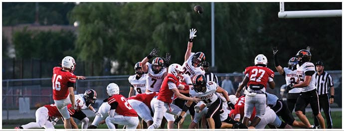 A football player is sliding on the ground. Description generated by AI