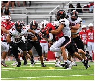 A group of football players wearing black and white uniforms. Description generated by AI