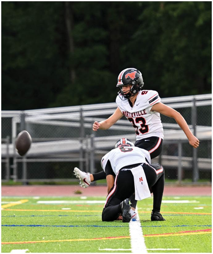 A group of football players wearing black and white uniforms. Description generated by AI