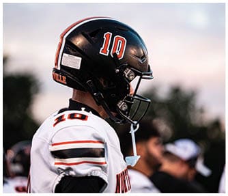 A group of football players wearing black and white uniforms. Description generated by AI