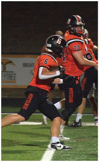 A football player catching a ball. Description generated by AI
