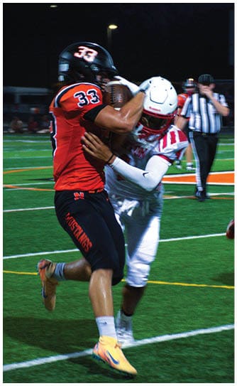 A football player catching a ball. Description generated by AI
