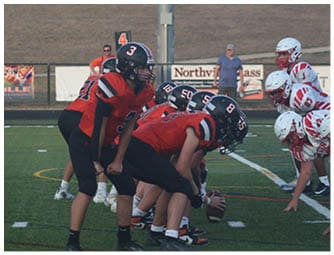 A group of football players on a field. Description generated by AI