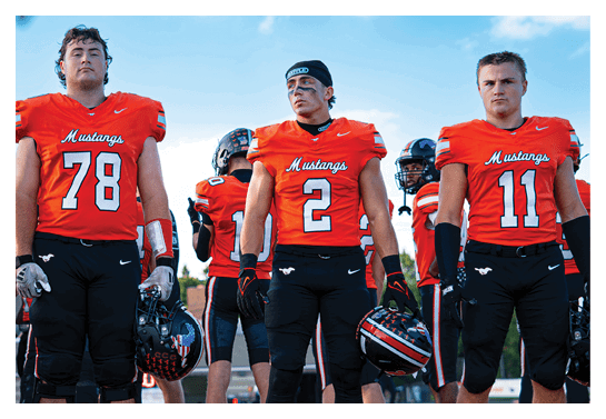 A group of football players wearing headphones and smiling. AI generated content