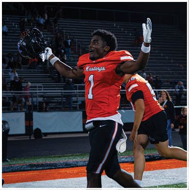 A football player running on the field. Description generated by AI