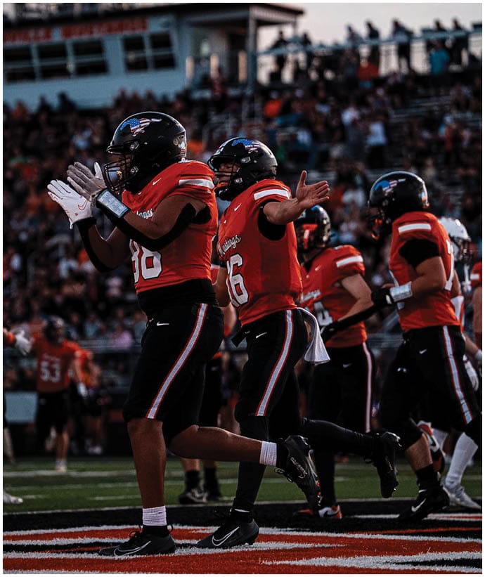 A group of football players wearing black and white uniforms. Description generated by AI