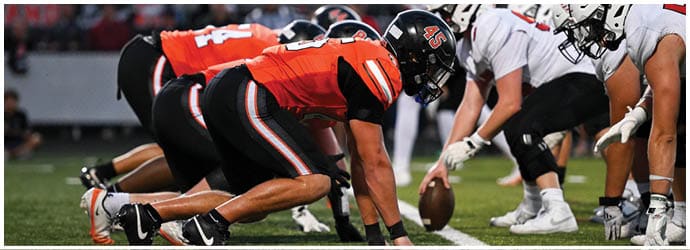 A group of football players on a field. Description generated by AI