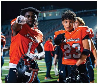 A group of football players wearing black and white uniforms. Description generated by AI