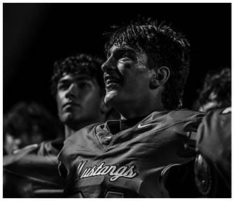 A group of football players wearing black and white uniforms. Description generated by AI